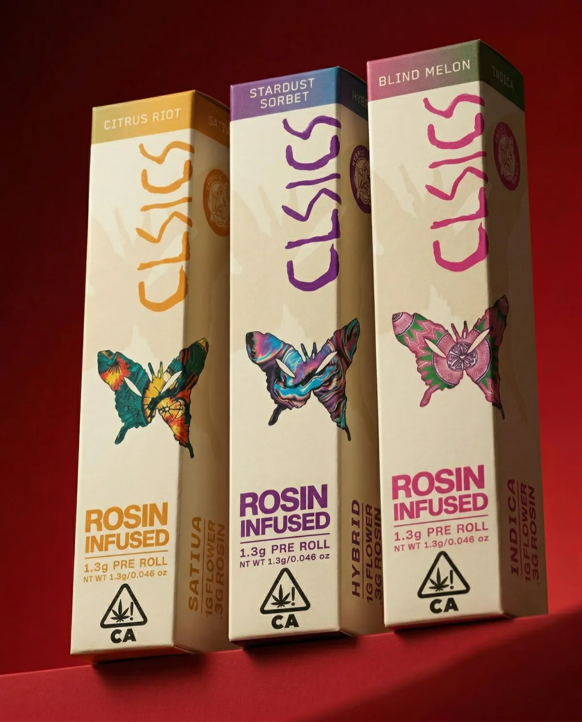 Three CLSICS rosin-infused pre-roll boxes, Citrus Riot, Stardust Sorbet and Blind Melon, on a red background