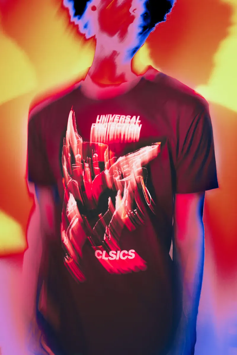 A man in a red CLSICS graphic tee against a blurred orange and red background
